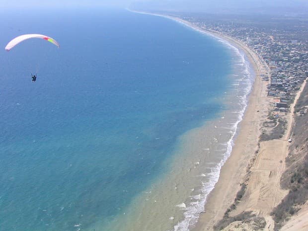 Paraglider flying over the long beach at Crucita