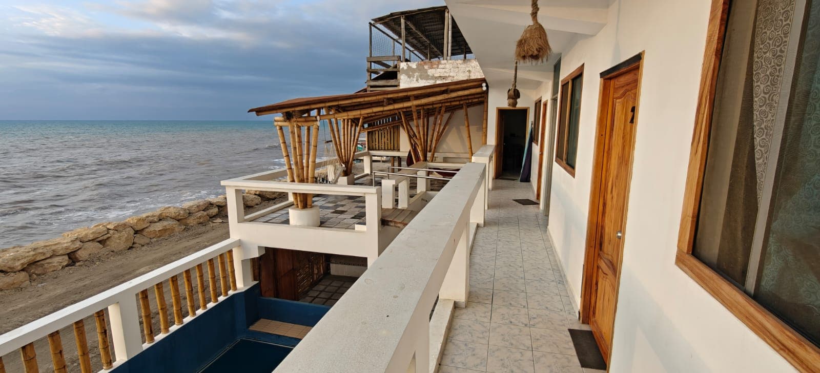 Balcony walkway outside the rooms, with the beach and the Pacific alongside