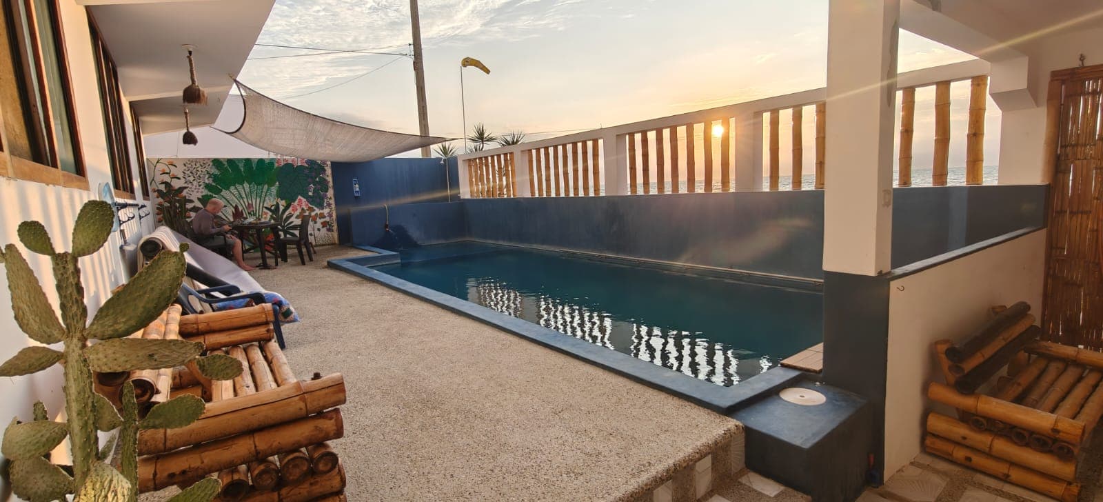 Swimming pool and lounge area at Hostal Cruzita at sunset