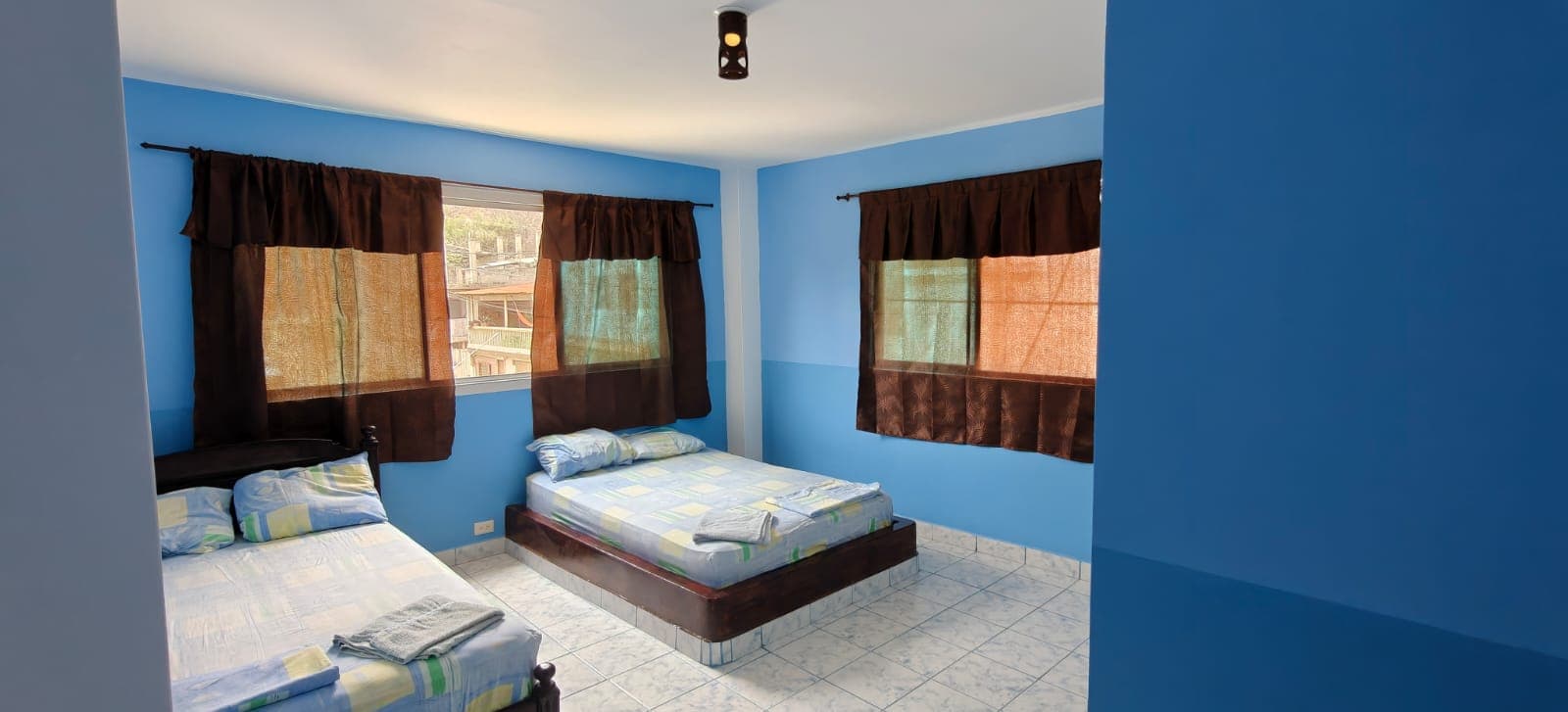Blue room with two beds at Hostal Cruzita