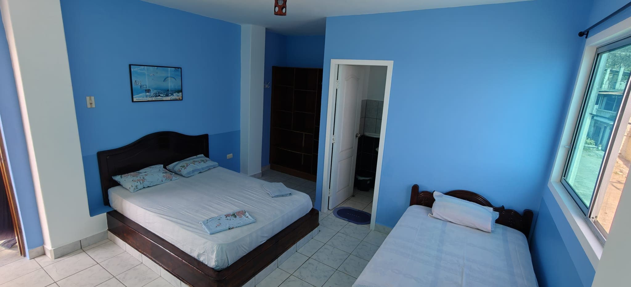 Blue room with a double bed, a single bed and a private bathroom